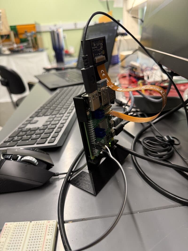 The Raspberry Pi 5 rig on its 3D-printed stand with the camera module mounted on top